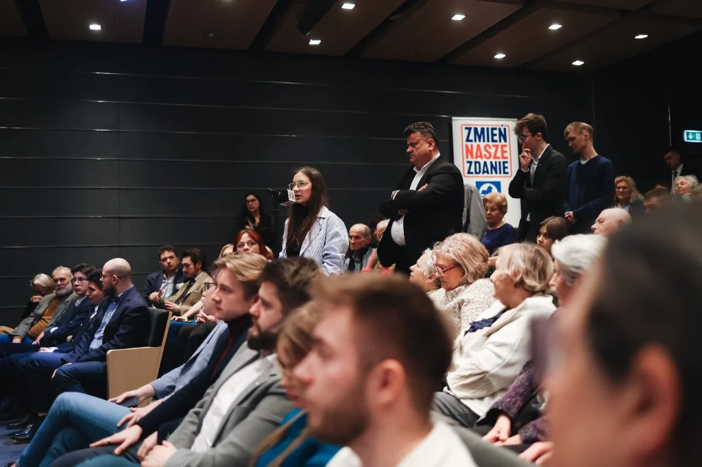 Uczestniczka zadająca pytanie z mikrofonem podczas debaty Zmień Nasze Zdanie.